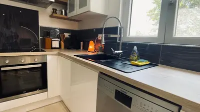 a kitchen with a sink and a counter top at LE HAVRE D'ATHENA - Grand appart, jardin privé, abri vélos & accès rapide A61 in Castelnaudary