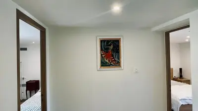 a room with a painting on the wall next to a bed at LE HAVRE D'ATHENA - Grand appart, jardin privé, abri vélos & accès rapide A61 in Castelnaudary