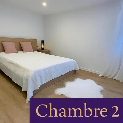 a bedroom with a white bed and a white rug at LE HAVRE D'ATHENA - Grand appart, jardin privé, abri vélos & accès rapide A61 in Castelnaudary