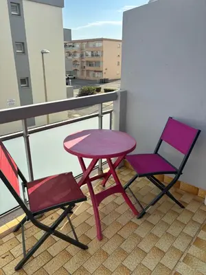 two chairs and a table on a balcony at T2 traversant, 2 balcons, 4 pers, proche plage in Port-la-Nouvelle