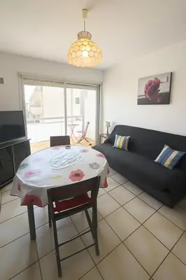 a living room with a table and a couch at T2 traversant, 2 balcons, 4 pers, proche plage in Port-la-Nouvelle
