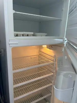 an empty refrigerator with its door open with its empty shelves at T2 traversant, 2 balcons, 4 pers, proche plage in Port-la-Nouvelle