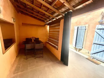an empty room with a table and a window at Parenthèse à Deux - T2 Cosy & Calme - Patio - Terrasse - Climatisé - Proche de la cité médiévale in Carcassonne