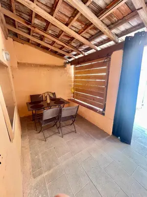 a dining room with a table and chairs and a window at Parenthèse à Deux - T2 Cosy & Calme - Patio - Terrasse - Climatisé - Proche de la cité médiévale in Carcassonne