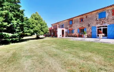 a large yard in front of a brick building at Authentique Maison Campagne in Montredon-Labessonnié