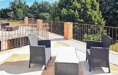 a patio with a table and chairs and a fence at Authentique Maison Campagne in Montredon-Labessonnié