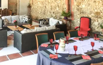 a room with a table and chairs and a couch at Authentique Maison Campagne in Montredon-Labessonnié