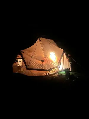 a tent is lit up in the dark at Domaine du Fourtet in Arfons
