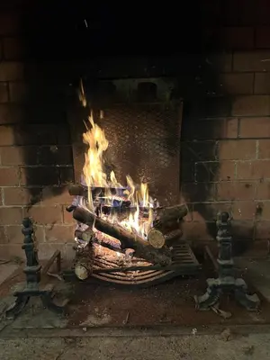 a fire is burning in a brick fireplace at Domaine du Fourtet in Arfons