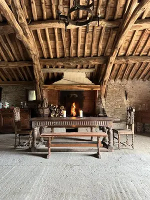 a fireplace in a room with a bench and a table at Domaine du Fourtet in Arfons