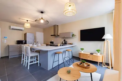 a kitchen and living room with a large island with stools at Plein centre - climatisé - à proximité cité médiévale in Carcassonne