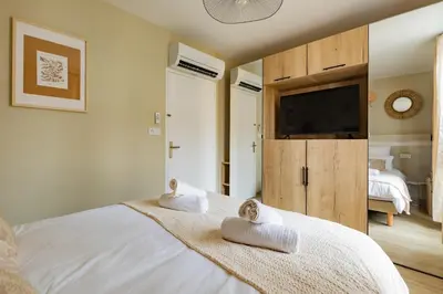 a bedroom with a large white bed with two towels at Plein centre - climatisé - à proximité cité médiévale in Carcassonne