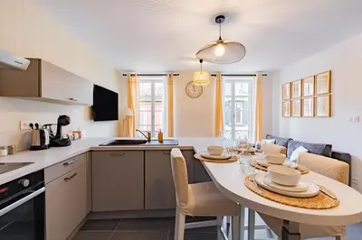 a kitchen and dining room with a table and chairs at Plein centre - climatisé - à proximité cité médiévale in Carcassonne