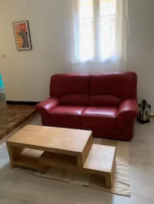 a red couch in a living room with a coffee table at Carcassonne Studio in Carcassonne