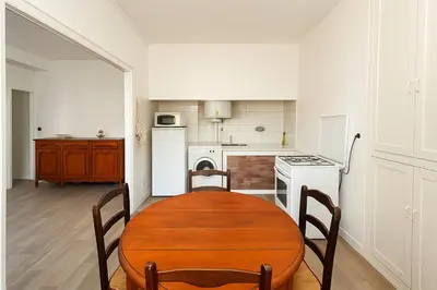 a kitchen with a wooden table and chairs in a room at Appartement rénové avec 2 chambres et espace bien-être Lavelanet in Lavelanet