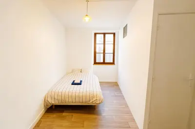 a bedroom with a bed in the corner of a room at Appartement rénové avec 2 chambres et espace bien-être Lavelanet in Lavelanet