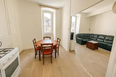 a kitchen and living room with a table and chairs at Appartement rénové avec 2 chambres et espace bien-être Lavelanet in Lavelanet