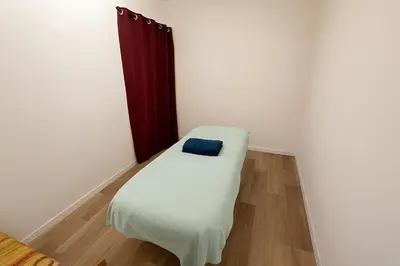 a small white bed with a blue pillow on it at Appartement rénové avec 2 chambres et espace bien-être Lavelanet in Lavelanet