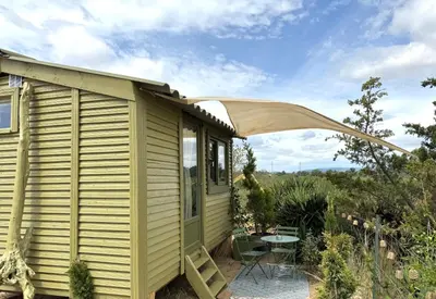 a yellow tiny house with a patio and a table at La paillote , confort toutes saisons in Moussan
