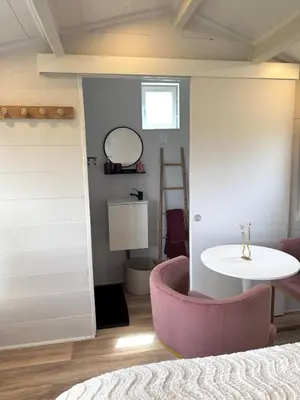 a room with a pink chair and a table at La paillote , confort toutes saisons in Moussan