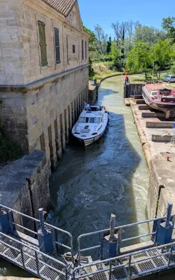 a boat is docked in a canal next to a building at La paillote , confort toutes saisons in Moussan
