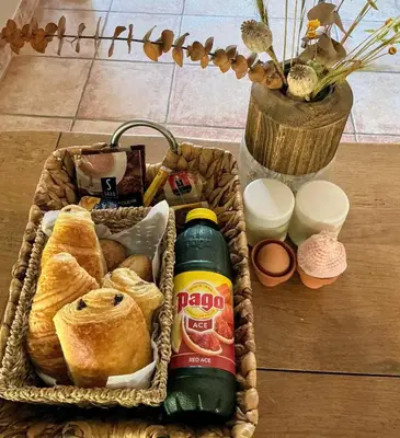 a basket filled with bread and a bottle of sauce at La paillote , confort toutes saisons in Moussan