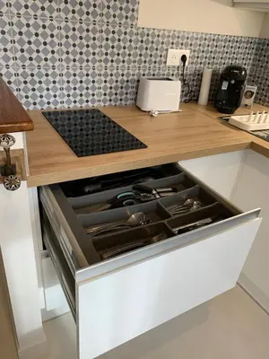 an open drawer in a kitchen with a stove at Nusa in Narbonne