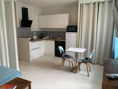 a small kitchen with a table and two chairs at Nusa in Narbonne