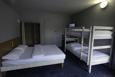 a bedroom with two bunk beds and a room with at Rocade capsule bungalow in Pamiers