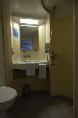 a bathroom with a toilet and a sink with a mirror at Rocade capsule bungalow in Pamiers