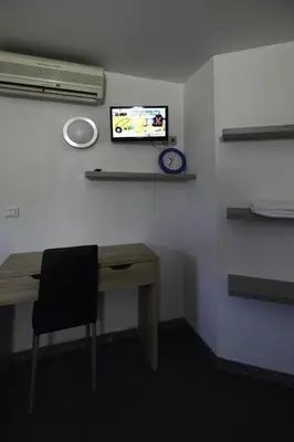 a room with a desk and a tv on a wall at Rocade capsule bungalow in Pamiers