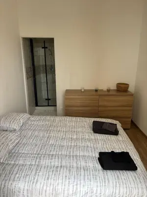 a bedroom with a bed with two black towels on it at Appartement Moderne au centre de NARBONNE in Narbonne
