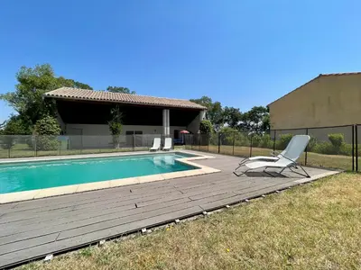 a chair sitting on a deck next to a swimming pool at Le Gîte de Barrau in Fenouillet-du-Razès
