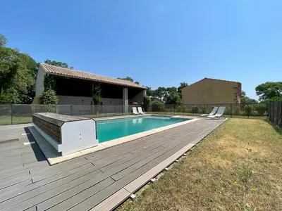 a swimming pool with a wooden deck next to a house at Le Gîte de Barrau in Fenouillet-du-Razès