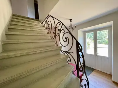 a staircase with a black and white wrought iron railing at Le Gîte de Barrau in Fenouillet-du-Razès