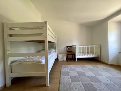 a bedroom with two bunk beds and a crib at Le Gîte de Barrau in Fenouillet-du-Razès