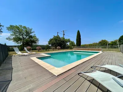 a swimming pool on a wooden deck with chairs around it at Le Gîte de Barrau in Fenouillet-du-Razès