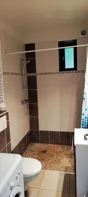 a bathroom with a shower with a toilet and a window at Gite du domaine de Couchalou in Fontjoncouse
