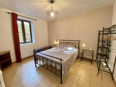a bedroom with a metal bed and a window at Gite du domaine de Couchalou in Fontjoncouse