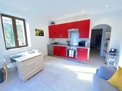 a kitchen with red cabinets and a couch in a room at Gite du domaine de Couchalou in Fontjoncouse