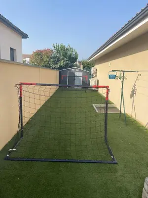 a batting cage in a yard with grass at Maison piscine vue Cité Carcassonne in Carcassonne