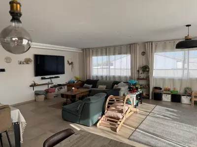a living room with a couch and a tv at Maison piscine vue Cité Carcassonne in Carcassonne