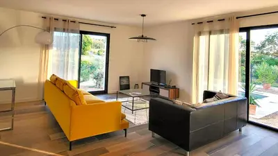 a living room with a yellow chair and a couch at Villa neuve calme - piscine privée - vue sur les vignes in Roquecourbe-Minervois