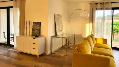 a living room with a yellow couch and a dresser at Villa neuve calme - piscine privée - vue sur les vignes in Roquecourbe-Minervois
