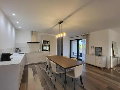 a kitchen and dining room with a table and chairs at Villa neuve calme - piscine privée - vue sur les vignes in Roquecourbe-Minervois