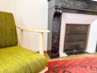 a green chair sitting in front of a fireplace at Evasion Vintage à Estagel - 4 pers - Terrasse in Estagel