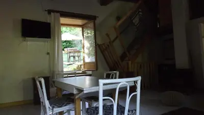 a dining room with a table and chairs and a window at Gîte mas Jourdane en Haut Languedoc in Anglès