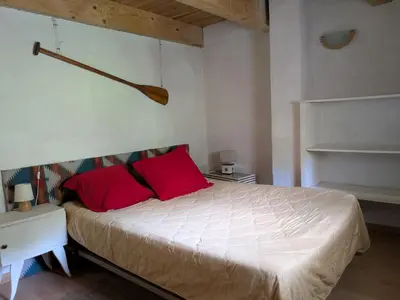 a bedroom with a large bed with red pillows at Gîte mas Jourdane en Haut Languedoc in Anglès