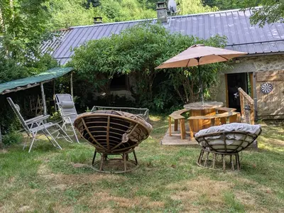 a yard with two baskets and a table and an umbrella at Gîte mas Jourdane en Haut Languedoc in Anglès