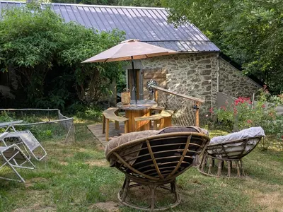 a table and chairs and an umbrella in a yard at Gîte mas Jourdane en Haut Languedoc in Anglès